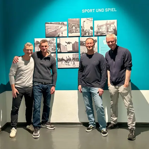 Jerôme Fuchs, Christian Wendland, Thomas Göring und Albert Retey im Jahr 2025 vor einem Bild von 1988